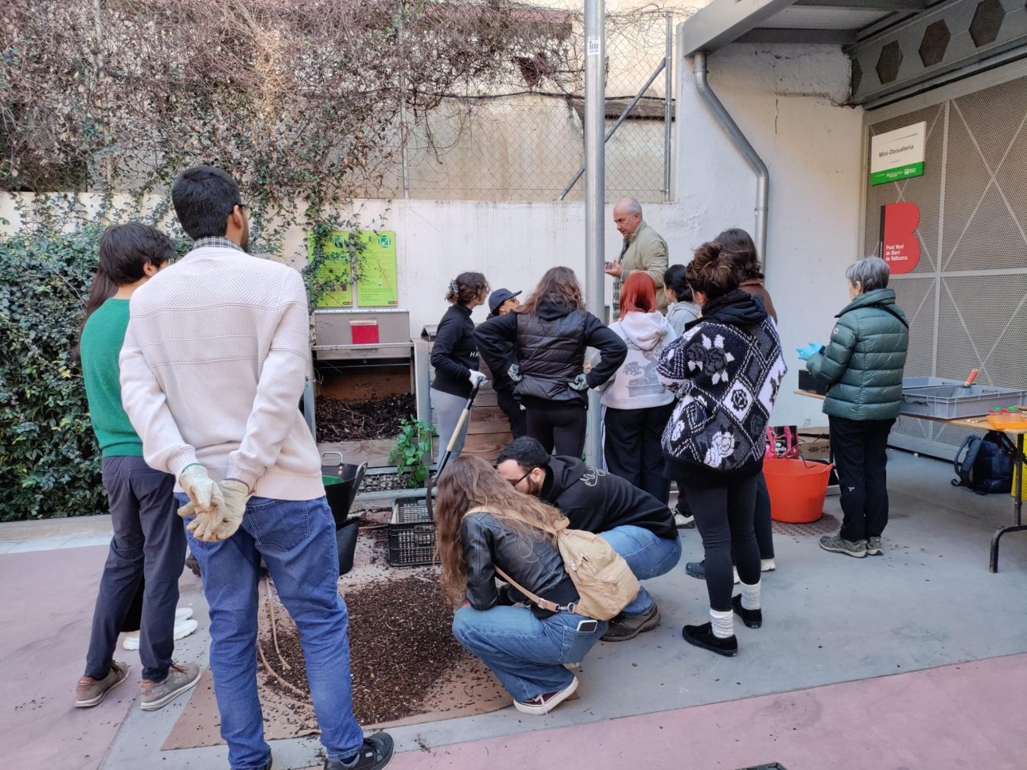 Imatge de la darrera jornada d'obtenció de compost al Punt Verd de Barri Vallcarca, amb un grup nombrós de persones durant el procés d'obtenció del compost.