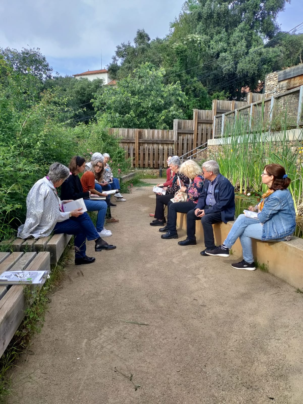 Fotografia de l'anterior lectura al bosc amb el grup de participants compartint reflexions a la vora de la bassa naturalitzada del Bosc Turull.