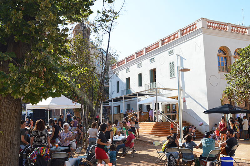 Plaça Farigola plena de famílies i vida en una jornada festiva davant del Casal de Barri Can Carol de Vallcarca.