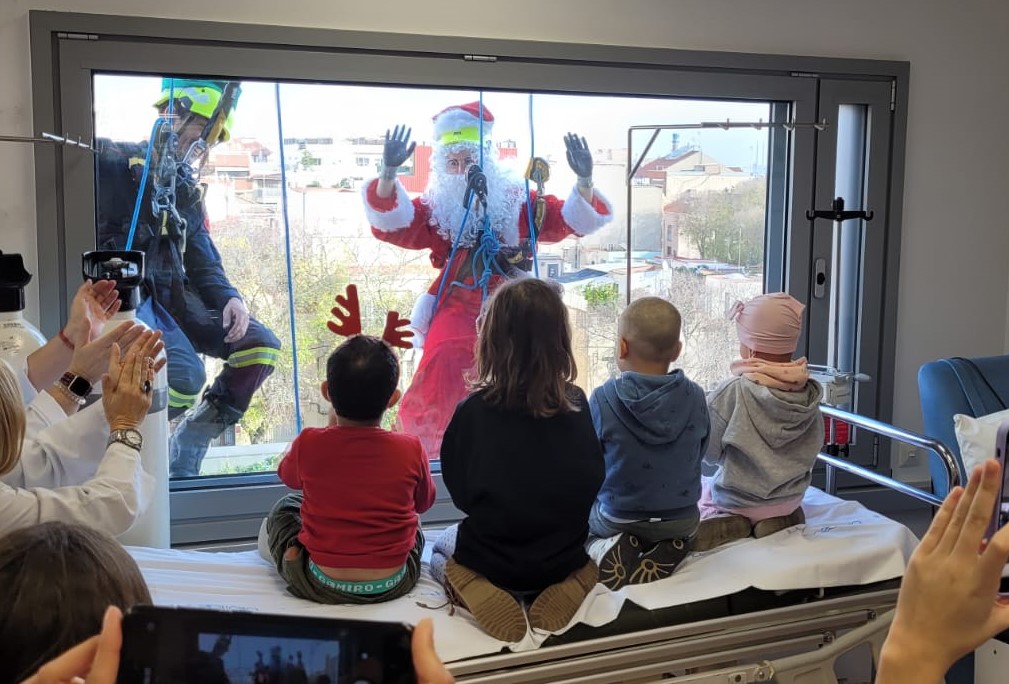 El Pare Noel saluda per la finestra als nens de l'Hospital de Sant Pau