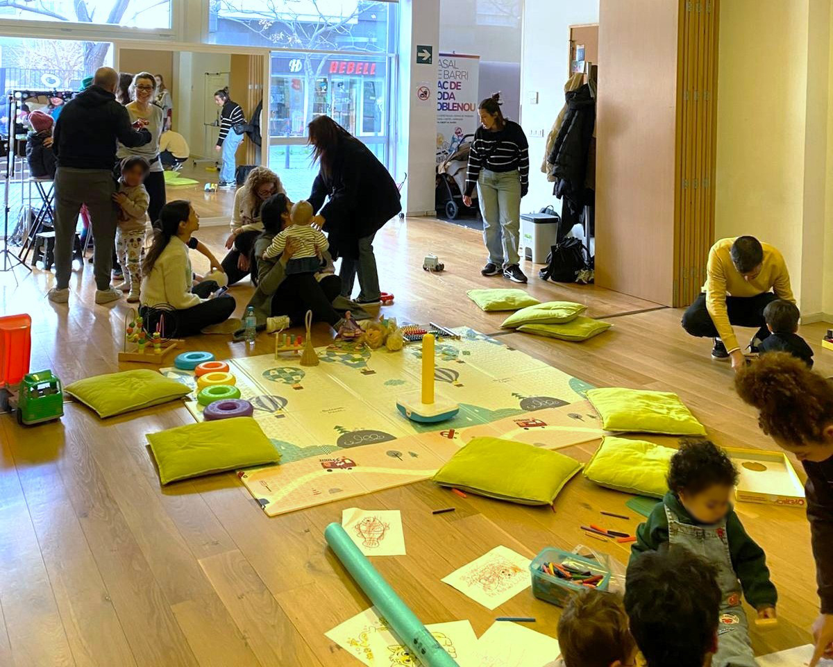 Sala amb famílies i un espai de jocs central