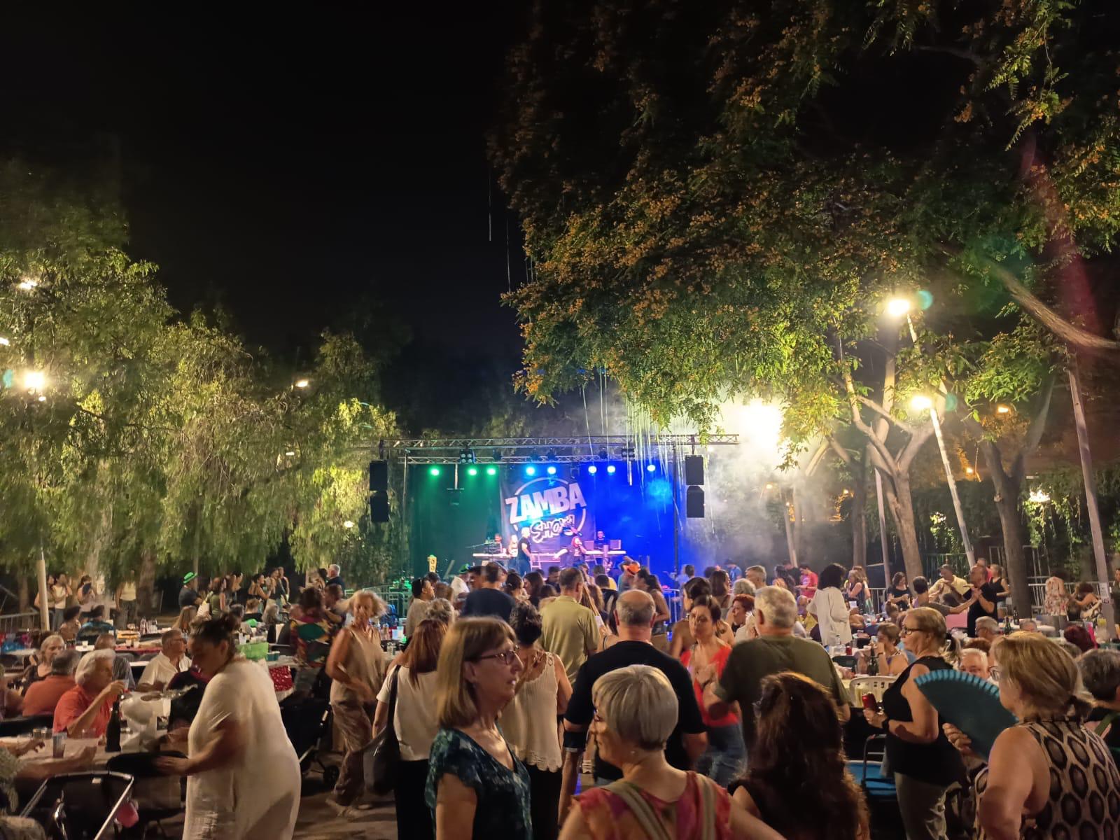 a la imatge es veu molta gent ballant i al fons, un escenari amb l'orquestra