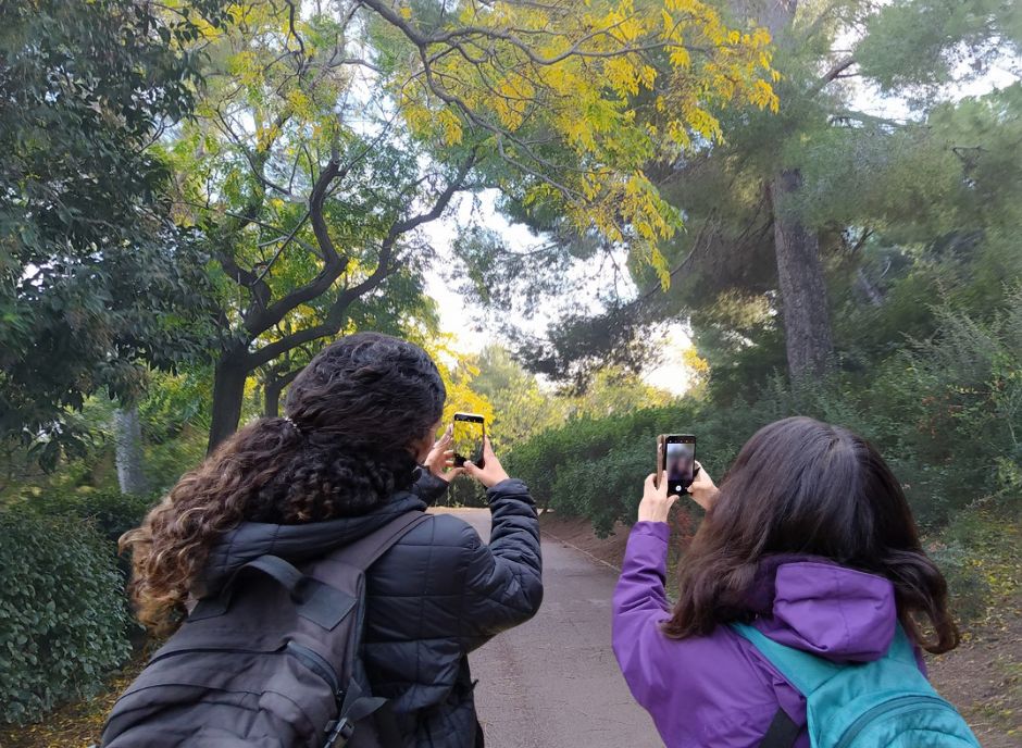 Exemple de dues noies fent fotografiant amb el mòbil imatges sobre la fenologia de les plantes al Parc del Putxet