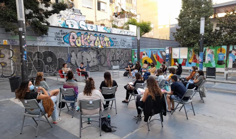 Persones assegudes en rotllana escoltant una xerrada