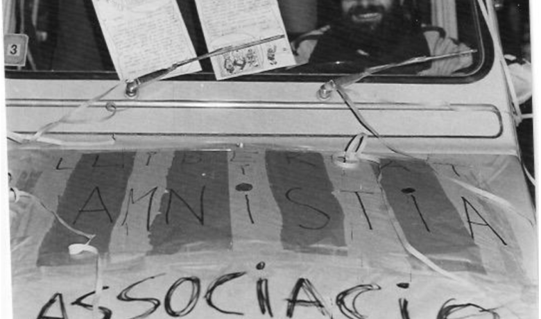 Fotografia dels anys 70 dins d'un cotxe tot pintat amb les paraules AMNISTIA i Associació dels veins del Poble-sec