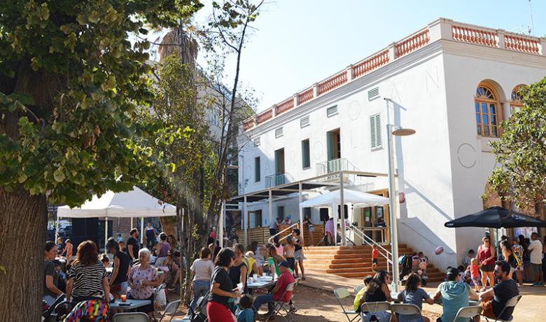 Plaça Farigola plena de famílies i vida en una jornada festiva davant del Casal de Barri Can Carol de Vallcarca.