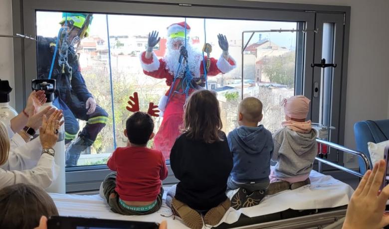 El Pare Noel saluda per la finestra als nens de l'Hospital de Sant Pau