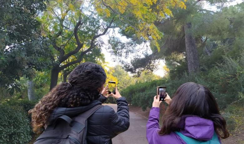 Exemple de dues noies fent fotografiant amb el mòbil imatges sobre la fenologia de les plantes al Parc del Putxet