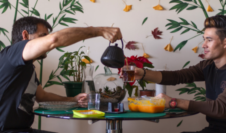 Dos nois comparteixen una tassa de té al voltant d'una taula