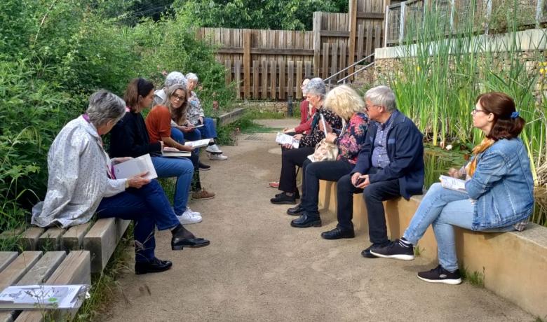 Fotografia de l'anterior lectura al bosc amb el grup de participants compartint reflexions a la vora de la bassa naturalitzada del Bosc Turull.