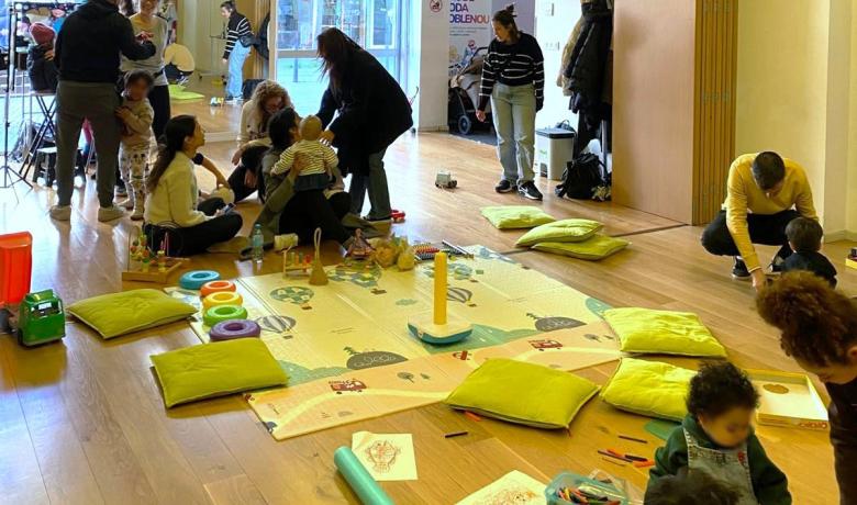 Sala amb famílies i un espai de jocs central