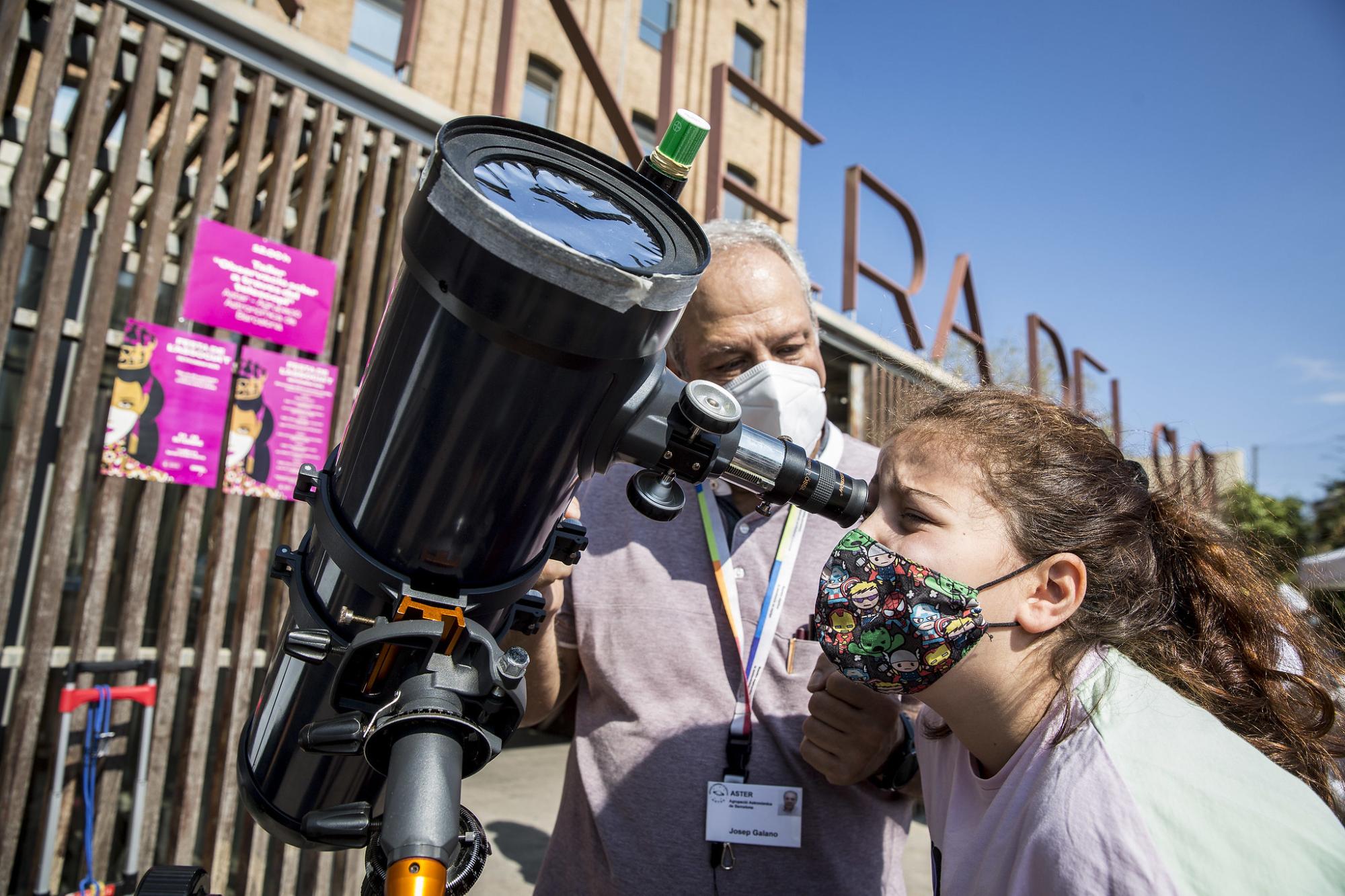 Una noia observa per un telescopi de l'Associació Aster Barcelona