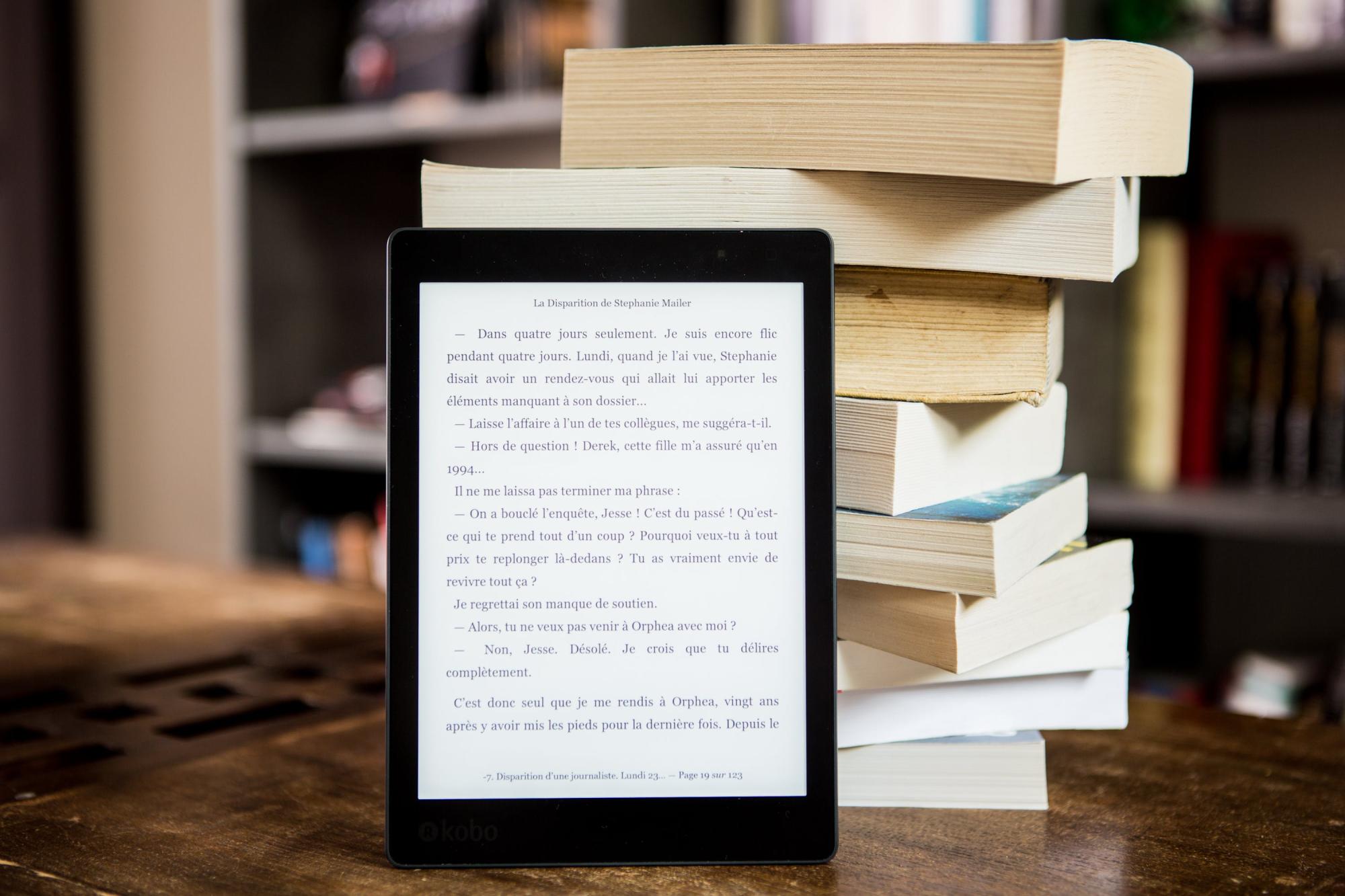 una pila de llibres i un lector d'ebooks