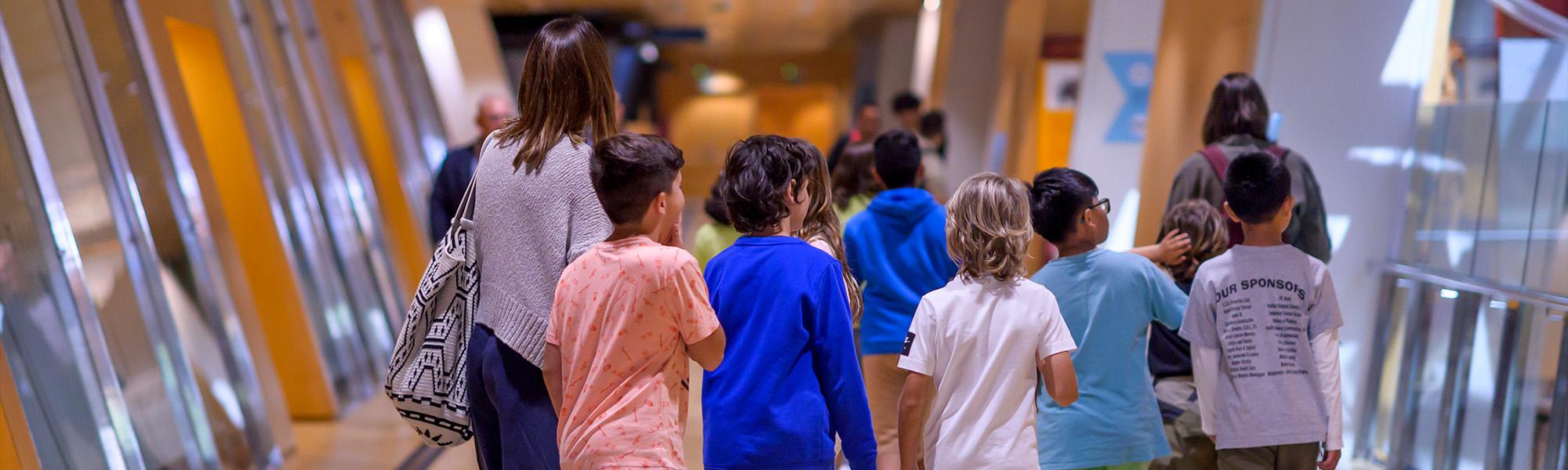 Un grup de nens i nenes acompanyats per adults mentre caminen.